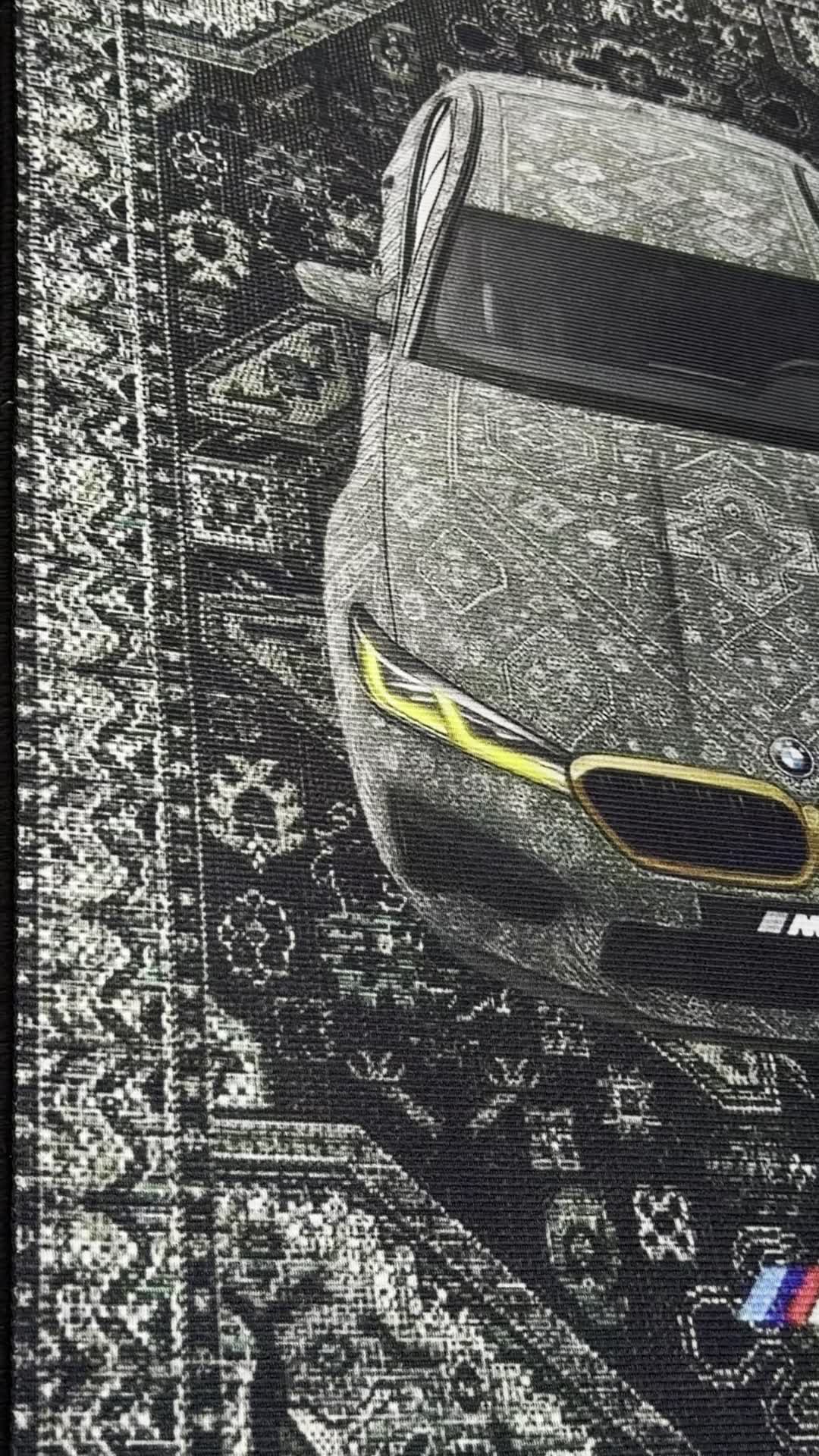 Close-up detail of the BMW M5 CS front grille and M Power lettering woven into the rug