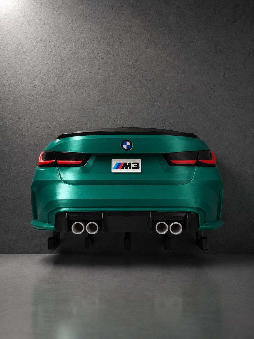 BMW M3 G80 rear-end key hook mounted on grey wall, front view