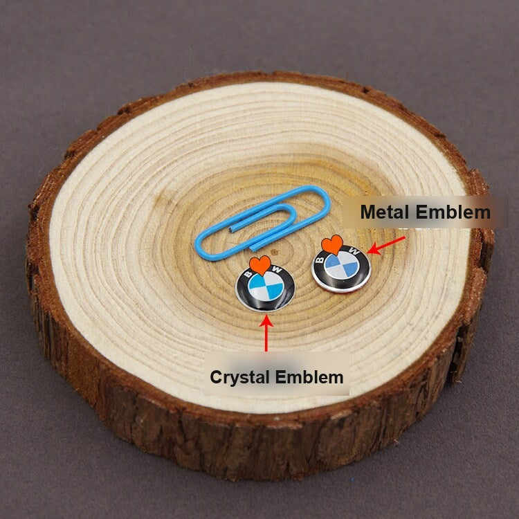 BMW metal and crystal key fob emblem size comparison next to a paperclip