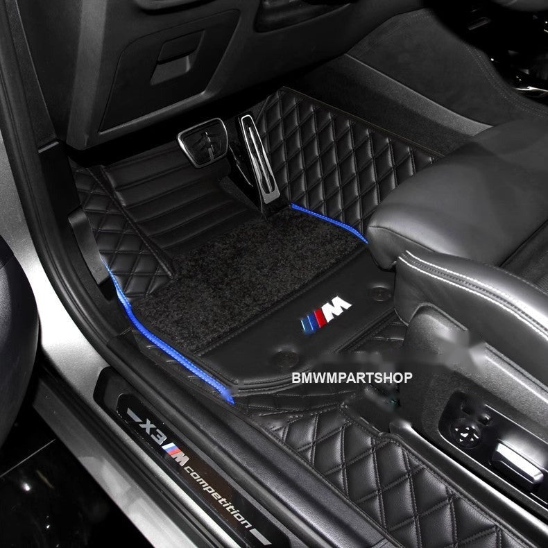 BMW custom floor mat installed in car footwell with blue trim stitching