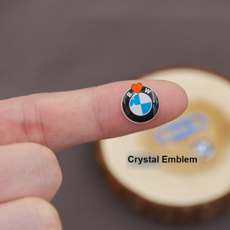 BMW crystal finish key fob emblem close-up on fingertip