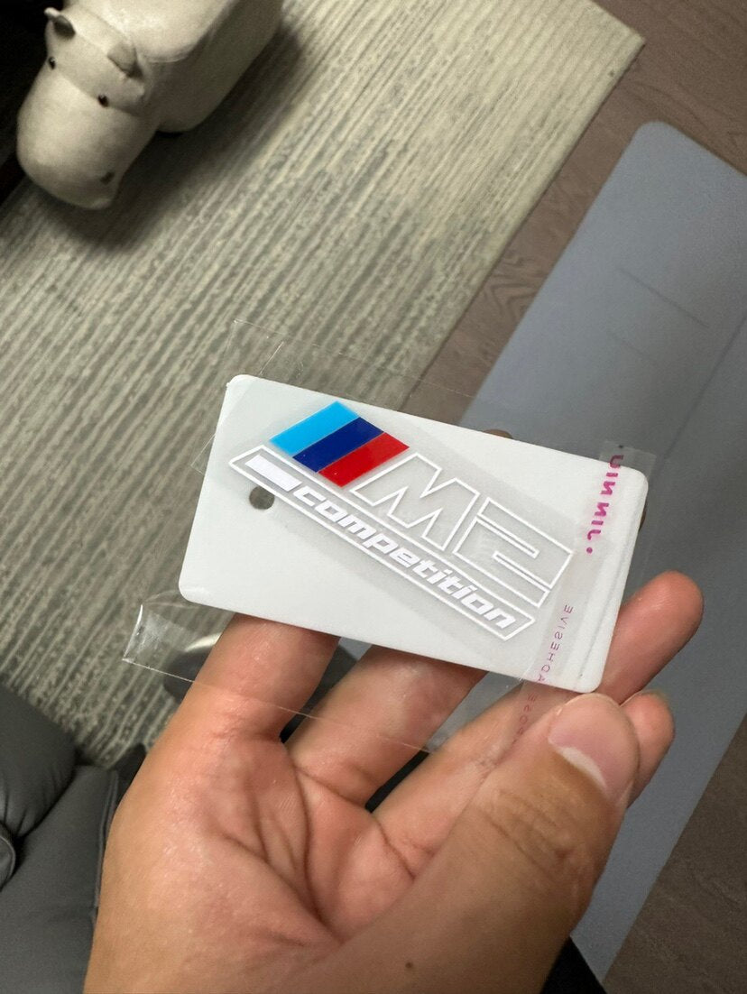 BMW M2 Competition center console badge sticker in hand