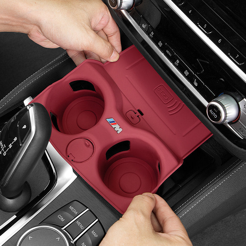 Hand holding BMW wireless charging cup mat silicone cover