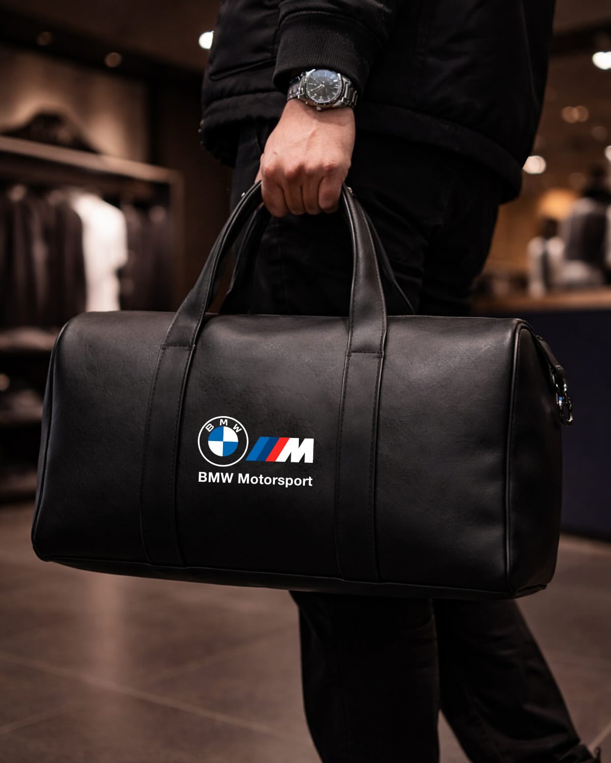 Man carrying BMW Motorsport black leather duffel bag